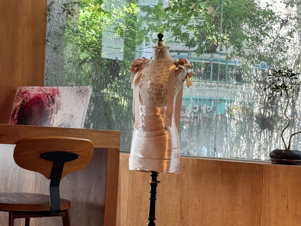 Tailor's dummy wrapped in pink satin ribbon